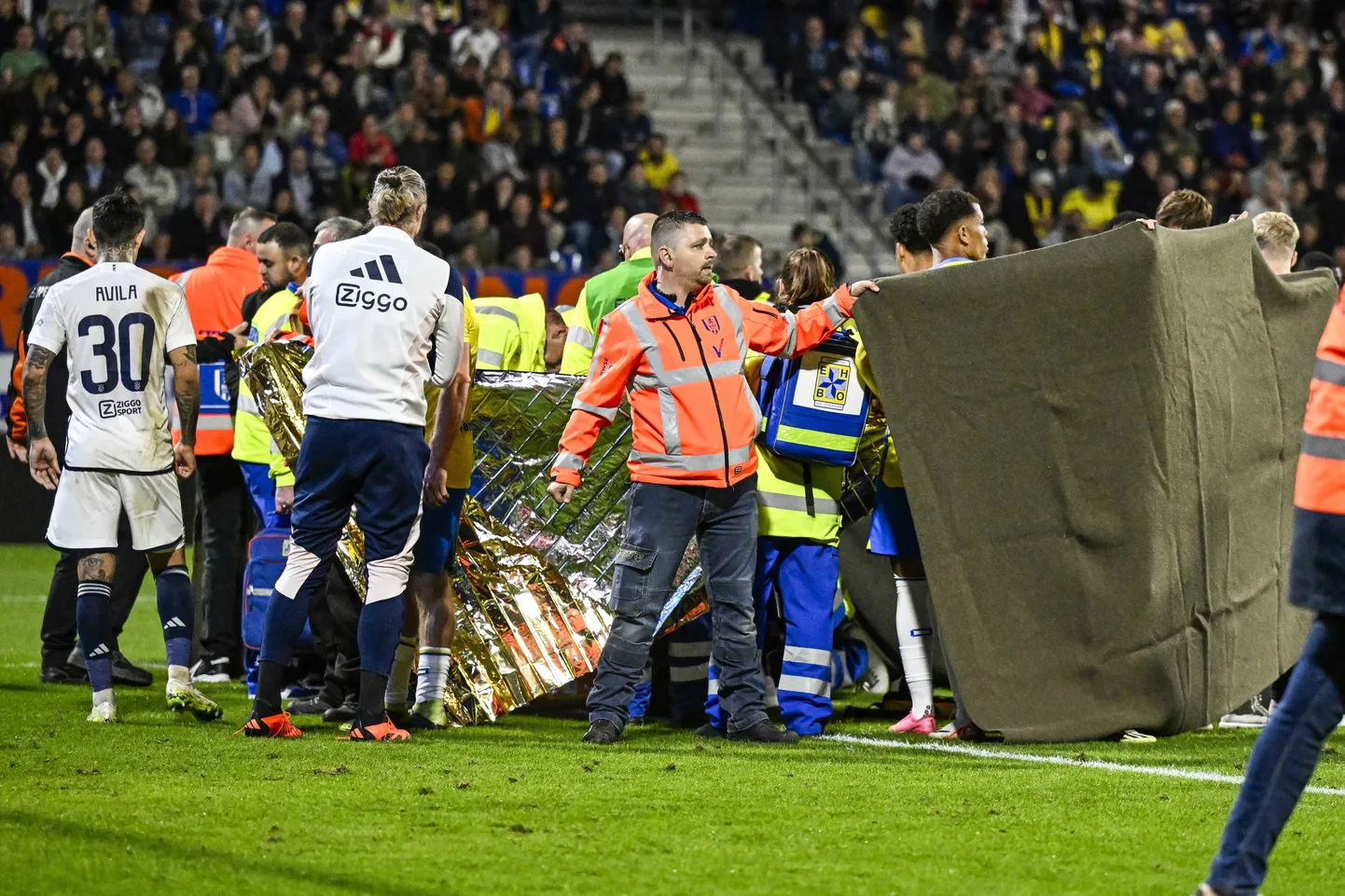 Mängijad ja turvatöötajad varjavad vaatevälja vigastada saanud väravavahi Etienne Vaesseni suunas.