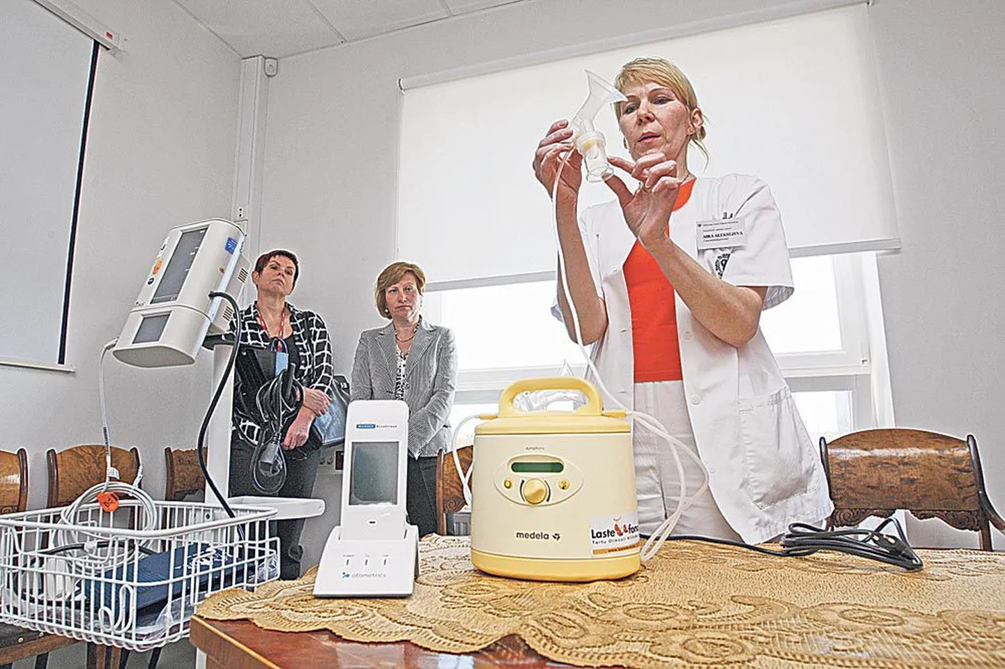 Naistekliiniku ämmaemand Aira Aleksejeva näitab, kuidas töötab rinnapump, sellest vasakul on kuulmisuuringuaparaat. Tagaplaanil seisavad suurannetajate esindajad, Ringtee Selveri juhataja Esta Soover (vasakul) ning Vahi Selveri juhataja Margit Järv.