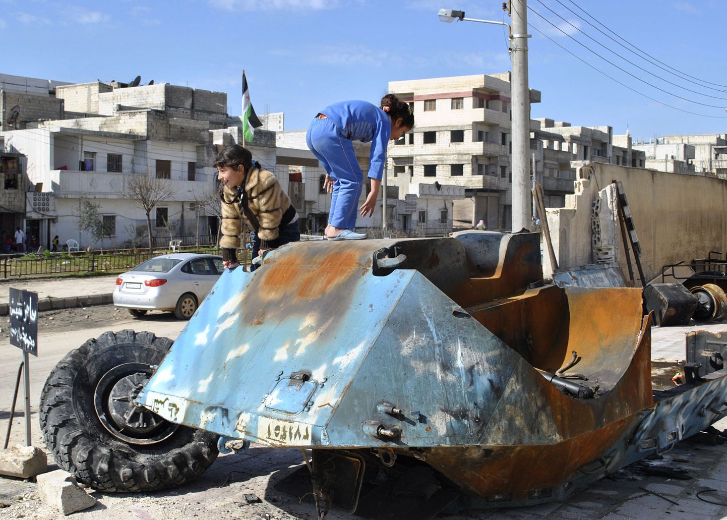 Tüdrukud mängivad Süüria sõjaväele kulunud tanki rusudel Homsi provintsis Bayadas.