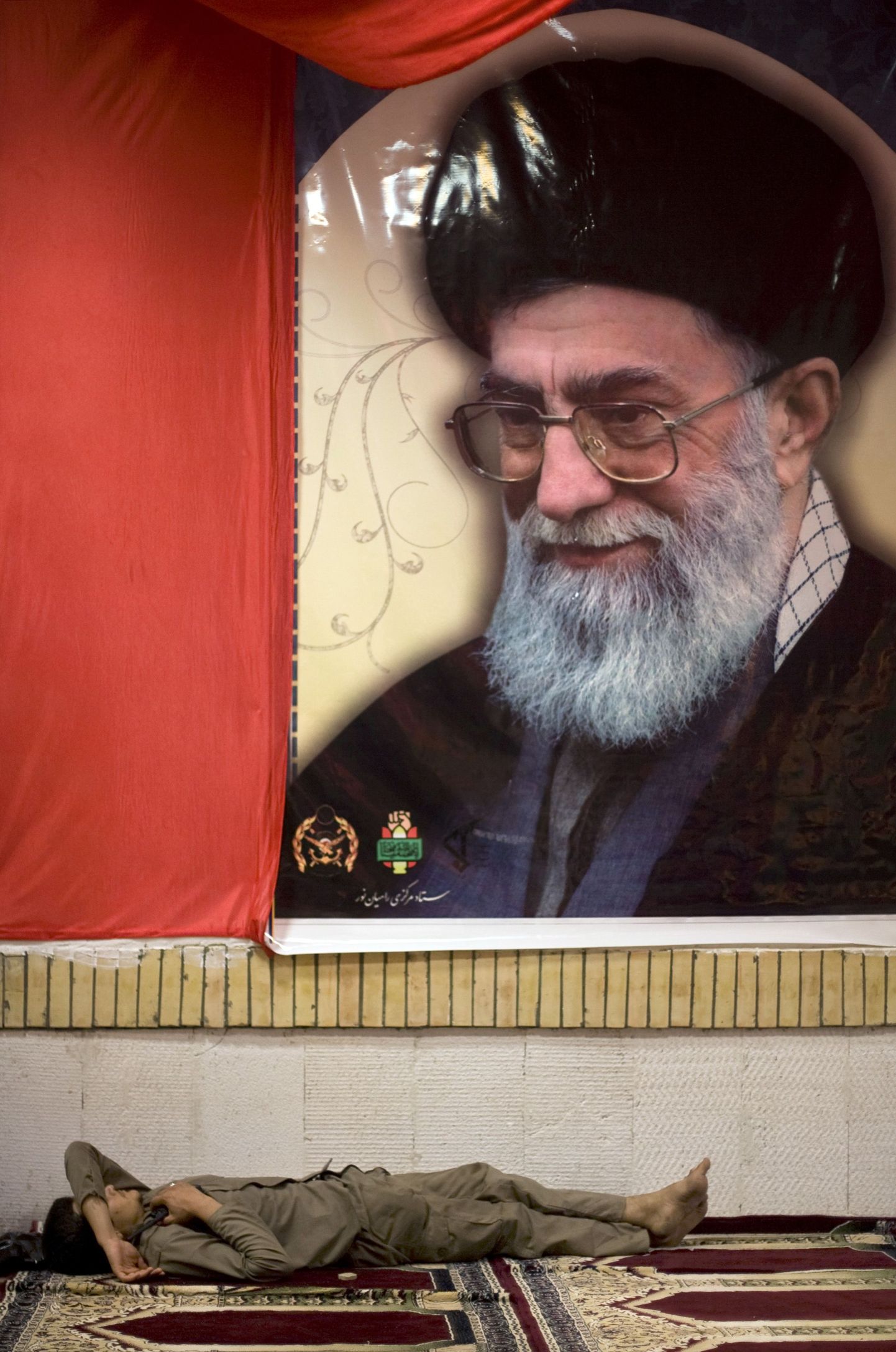 Iraani kõrgeima juhi ajatolla Ali Khamenei portree all tundmatu märtri pühamus magav mees.