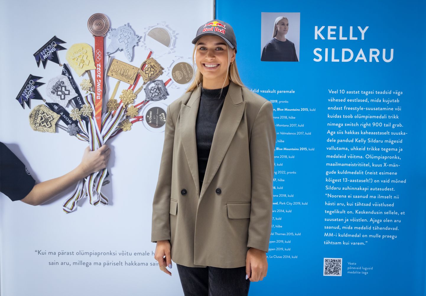 Kelly Sildaru poseerimas näitusel «Igihaljad» oma medalite ees.