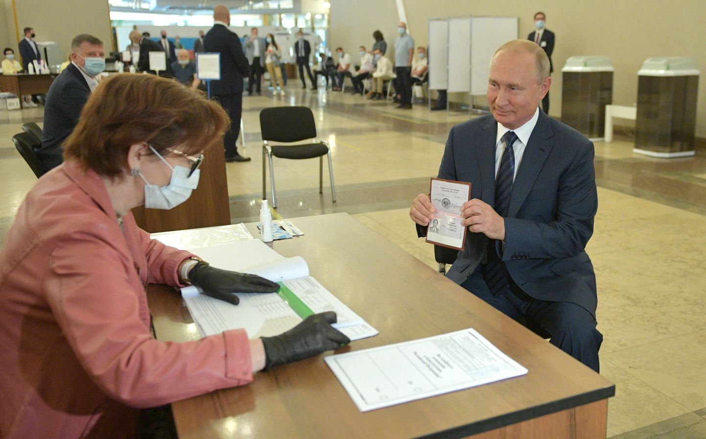 Vene president Vladimir Putin näitab valimiskomisjoni liikmele oma passi.