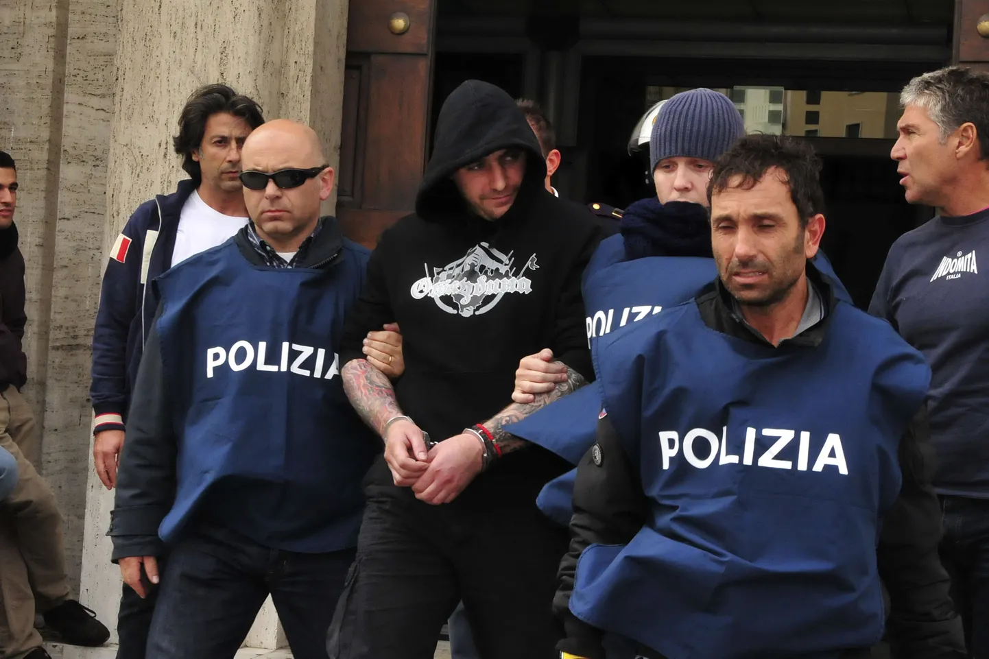 Ivan Bogdanov (mustas) Itaalia politsei valvsa pilgu all.