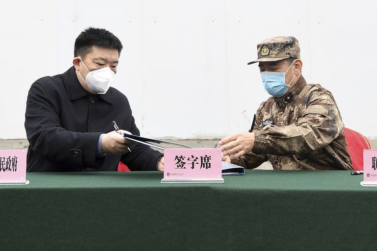 Wuhani linnapea Zhou Xianwang (vasakul) vahetamas lepingut Hiina rahva vabastusarmee logistikaosakonna juhi Bai Zhongbiniga. Sõjaväelased aitavad uue koroonaviirusega võidelda, vedades haiglatesse meditsiinivahendeid.