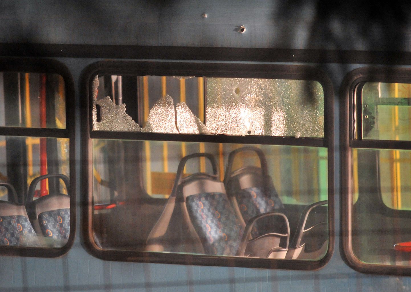 Kuuliaugud rünnaku alla langenud bussi akendes.