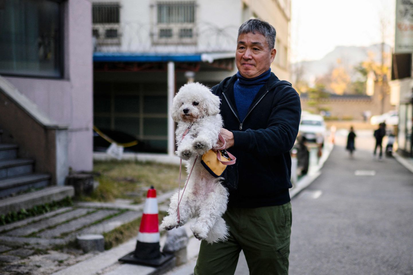 Mees koos koeraga Lõuna-Korea pealinna Souli tänaval.
