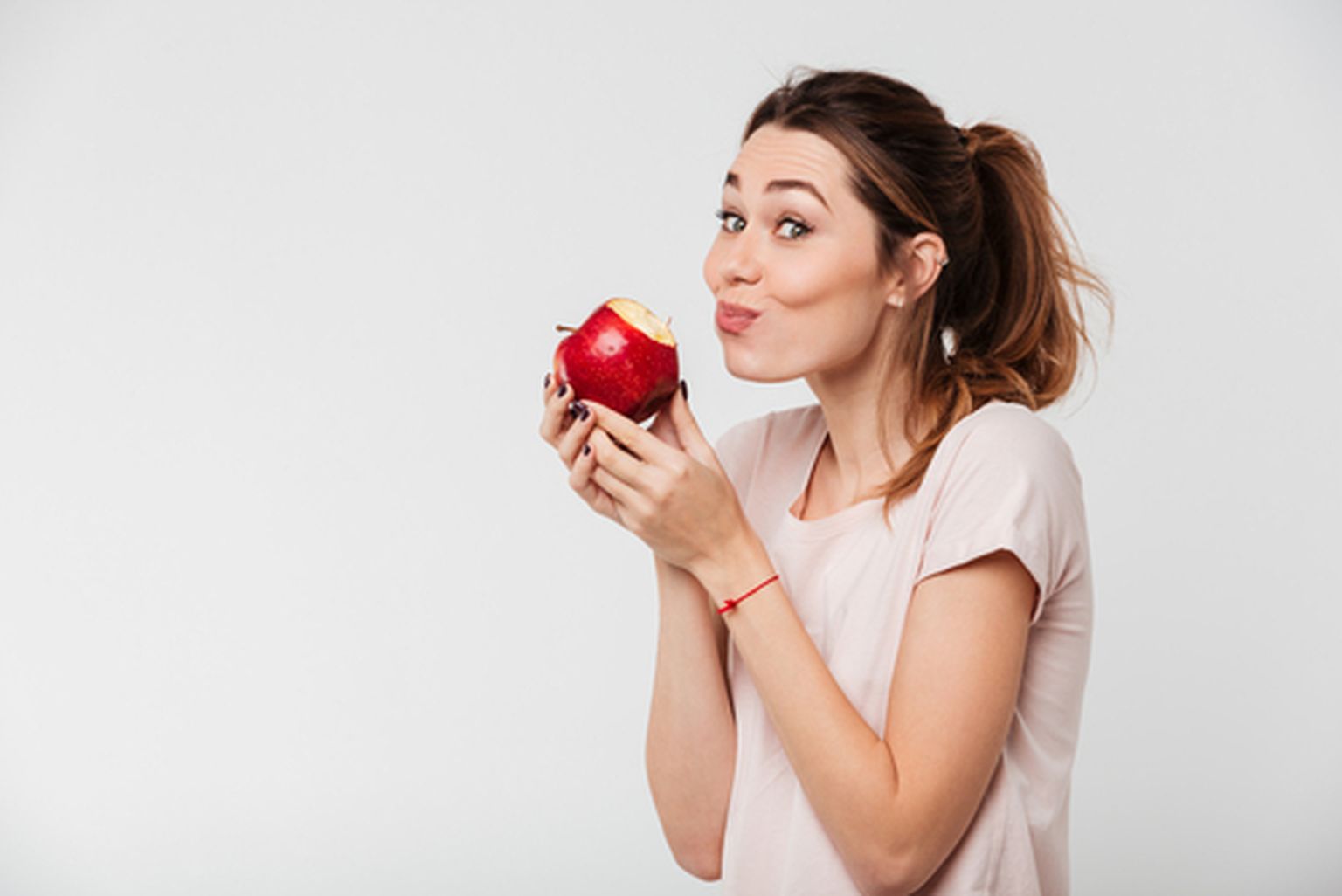 Женщина ест яблоко. Иллюстративное фото