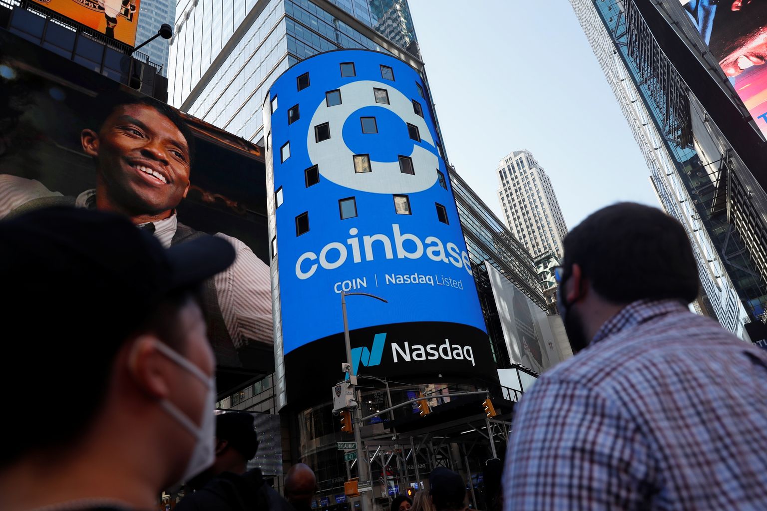 Inimesed New Yorgis Times Square’l Coinbase Globali logo imetlemas.