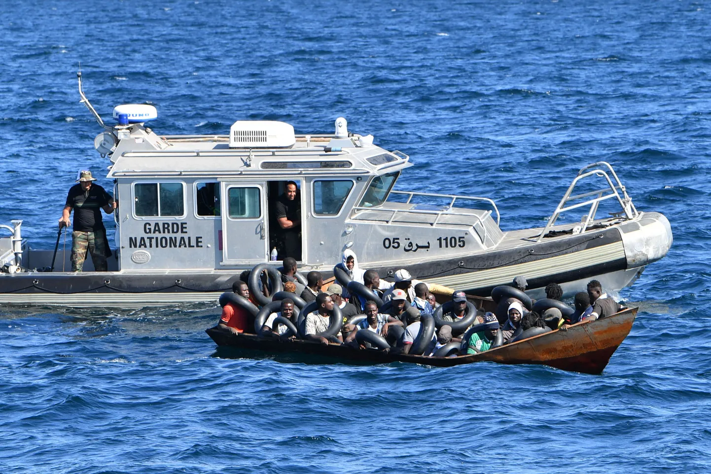 Tuneesia rannikuvalvelaev võtmas pardale väikepaadiga Euroopasse suundunud migrante. 10. august 2023.