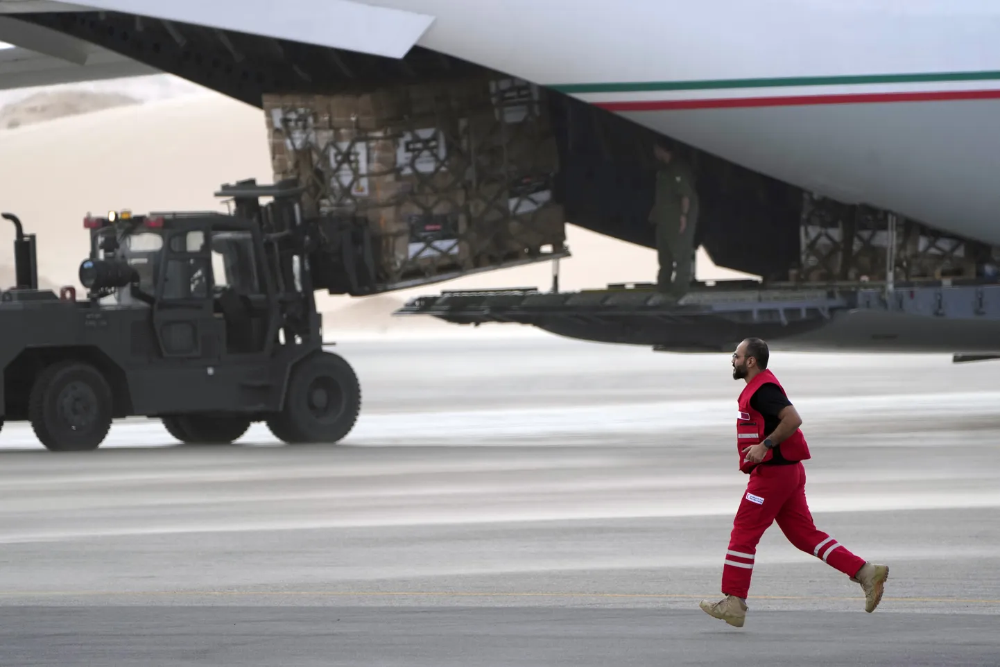 Katari Punase Risti vabatahtlik jooksmas Gazasse saadetava humanitaarabi laadiva sõiduki kõrval Egiptuse Al Arishi lennujaamas 19. novembril 2023.