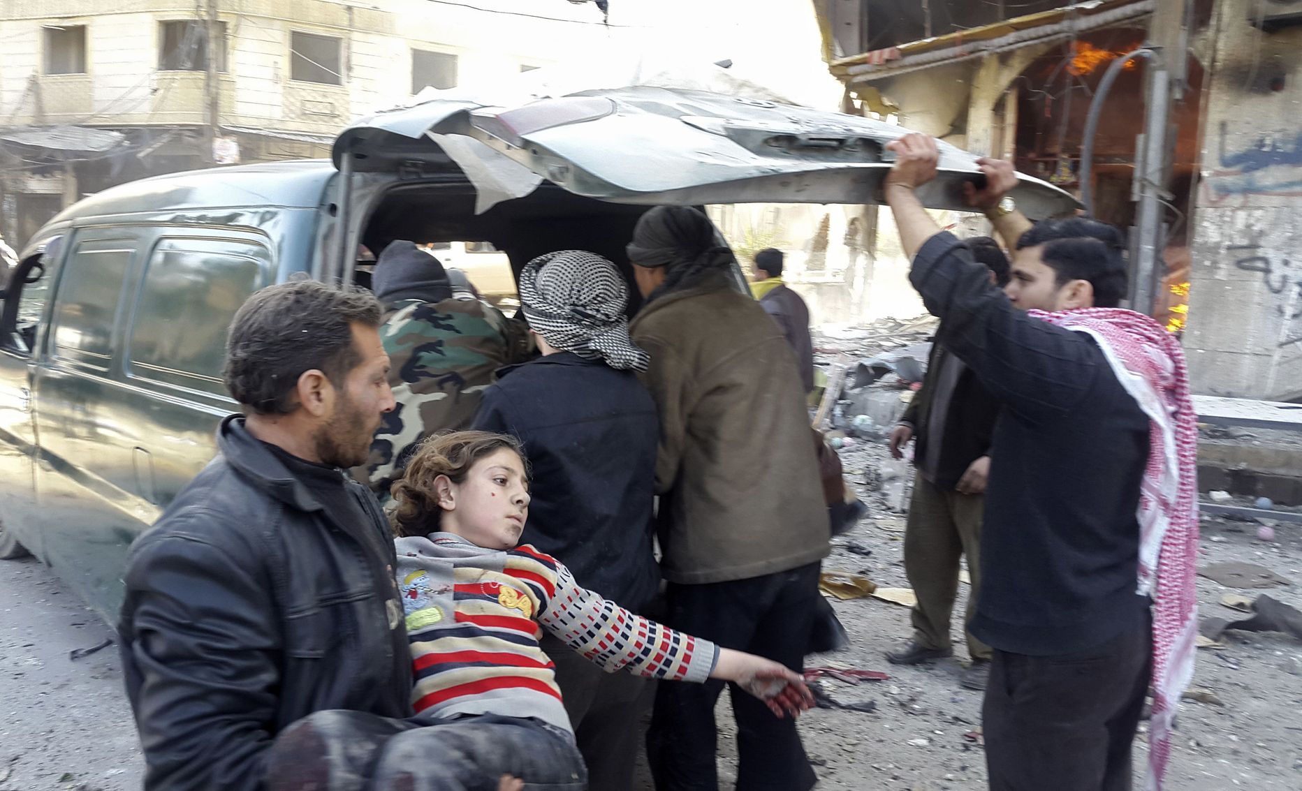 Mees kannab süles last, kes sai täna vigastada Damaskuse lähedal asuva küla vastu toime pandud valitsusvägede õhurünnakus.