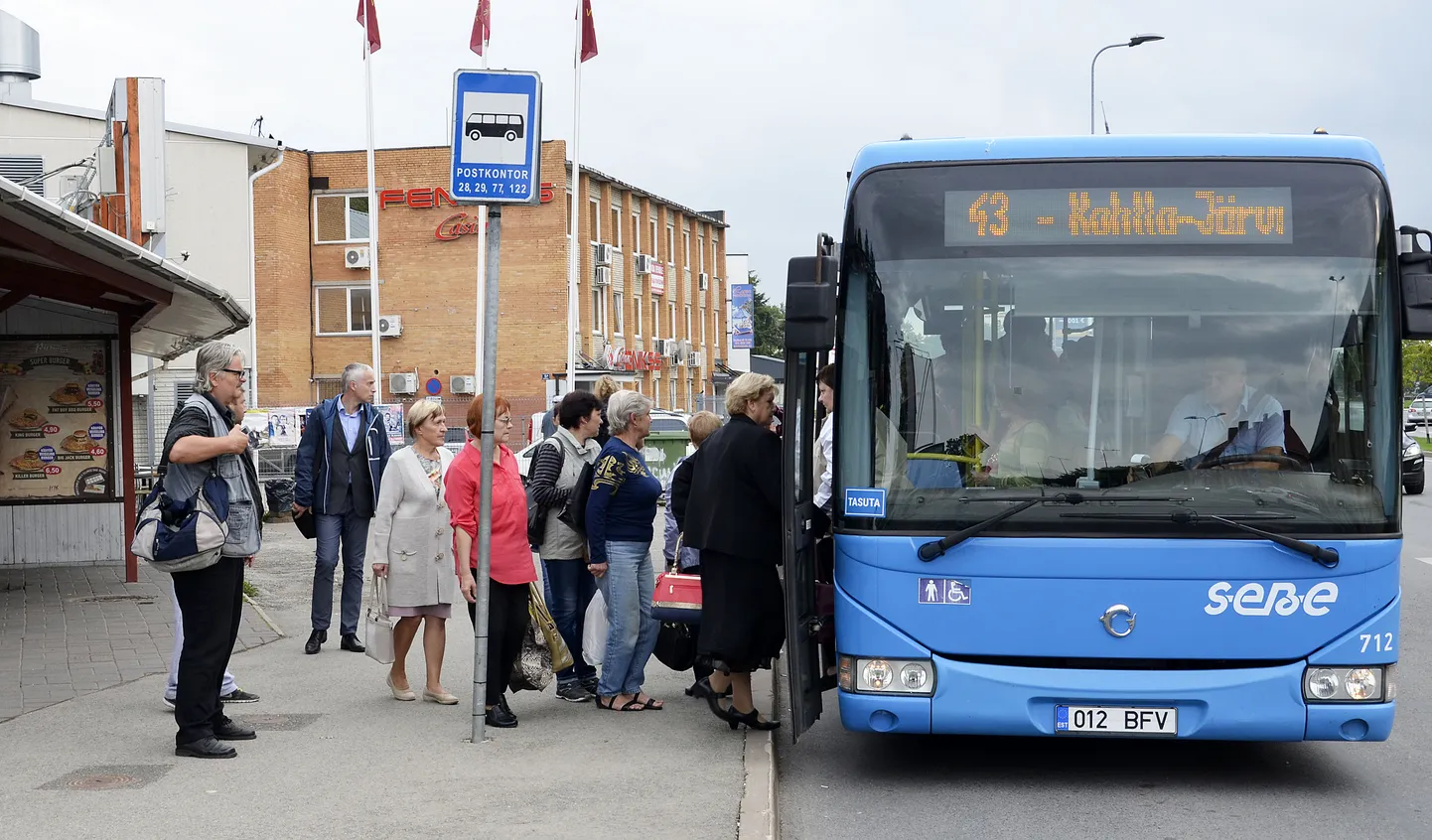 Пассажиры автобуса на автобусной остановке в Йыхви.