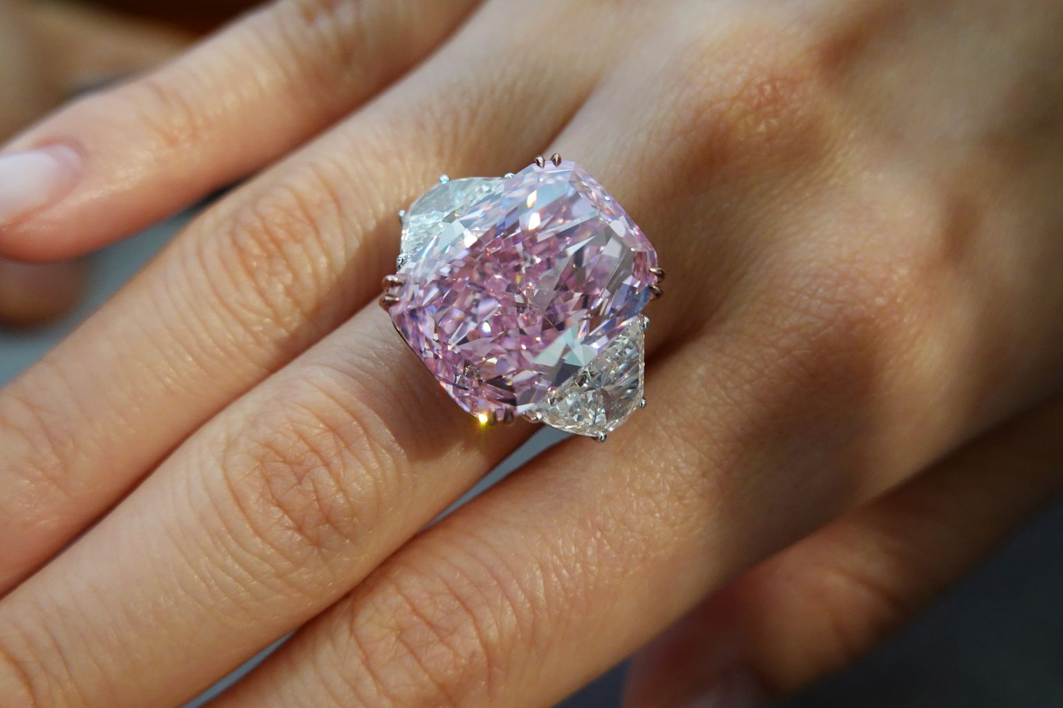 An employee poses with a 15.81 carat fancy vivid purple pink diamond ring, which is called The Sakura Diamond, during a preview at Christie’s ahead of the upcoming auction, in Hong Kong, China May 6, 2021. REUTERS/Joyce Zhou
