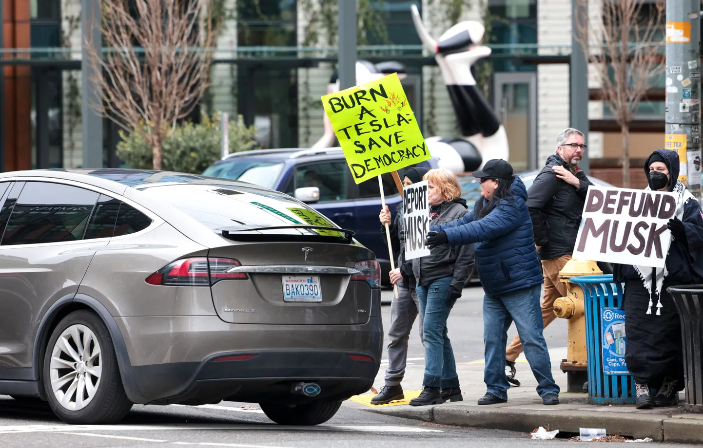 Cilvēki piedalās protesta akcijā “TeslaTakedown” pret Īlonu Masku pie Tesla izstāžu zāles Sietlā, Vašingtonā, 2025. gada 15. februārī.