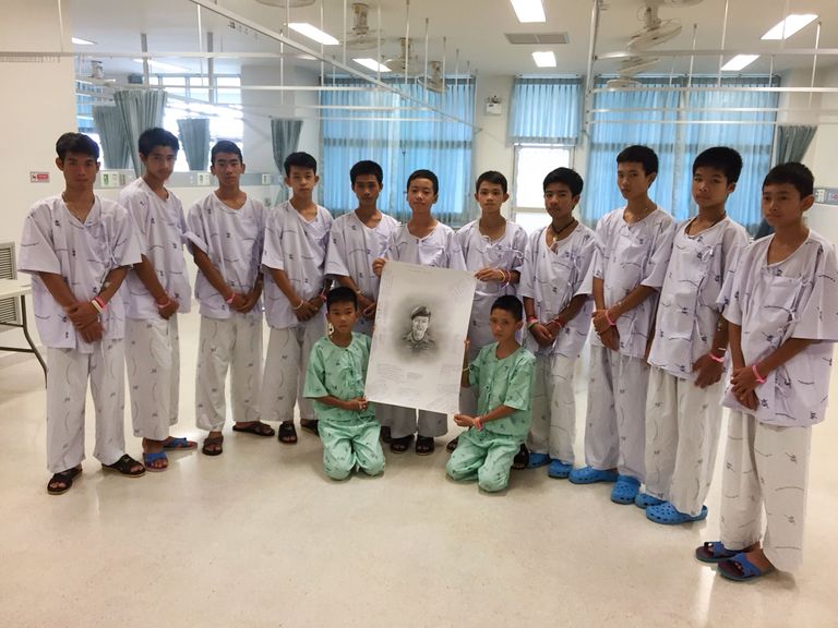 Tai jalgpallipoisid ja nende treener (vasakul esimene) pärast päästmist haiglas