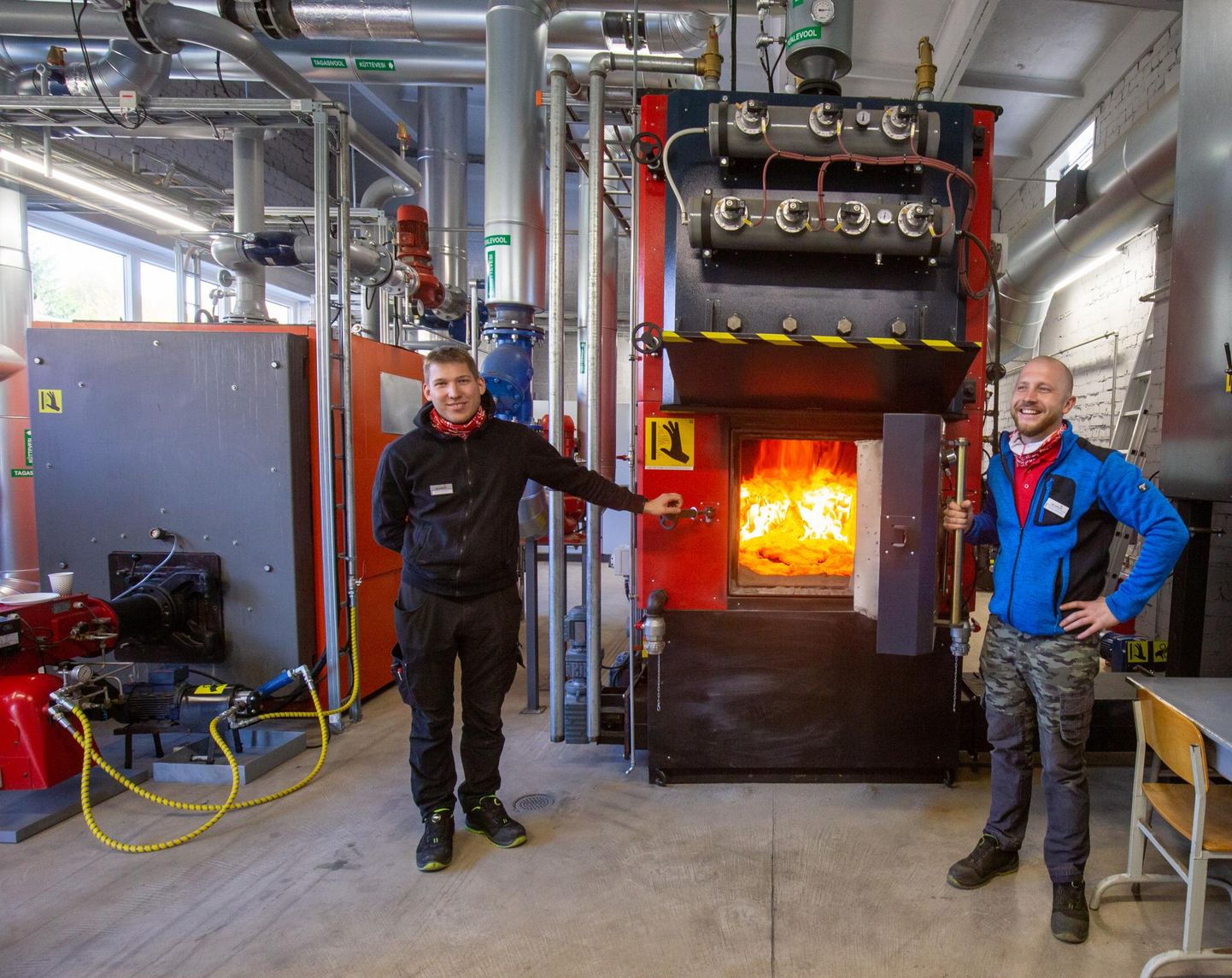 SW Energia hooldustehnikud Germo Kunimägi (vasakul) ja Oliver Kärblane näitavad hiljuti paika saanud katelt, mis annab sooja kõigile Abja-Paluoja soojavõrku ühendatud majadele.