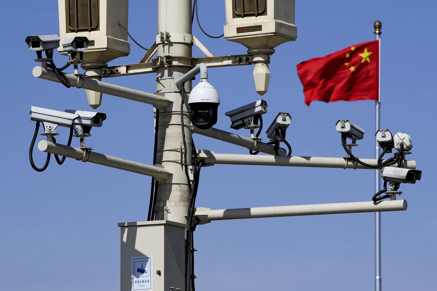 Hiina lipp lehvimas Tiananmeni väljakut jälgivate kaamerate taustal.
