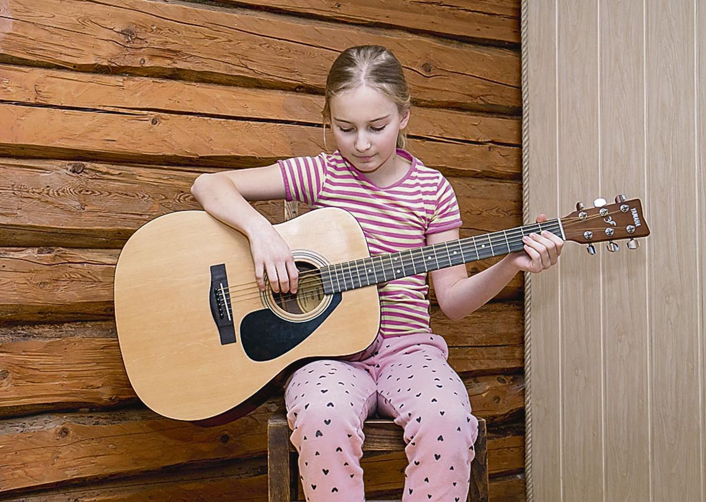Lembitu talu peretütar Helena harjutab koduski kitarrimängu.