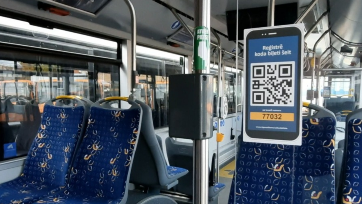 В автобусе, следующем из рижского аэрпорта в центр города, можно валидировать билет через QR-код, о чем сообщает надпись по-латышски.
