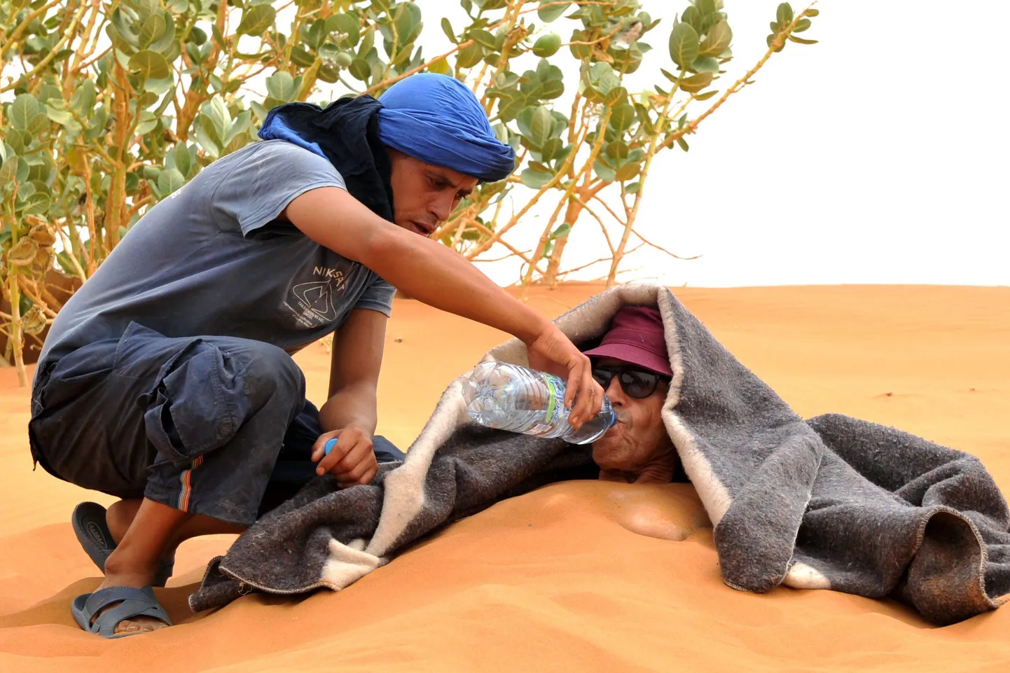 Turist Merzouga lähedal kõrbes liivateraapiasessiooni käigus.