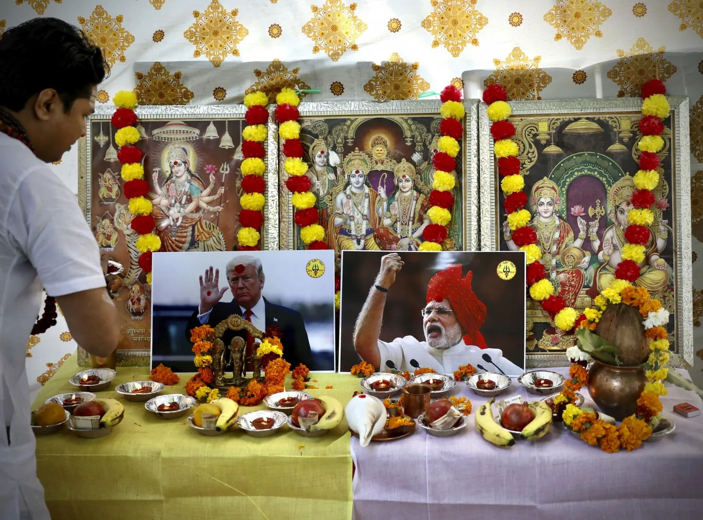 Hindu preester viimas Delhis läbi palvetseremooniat India peaministri Narendra Modi ja USA presidendi Donald Trumpi pildi juures, mis on asetatud hindu jumalate kujutiste keskele. 