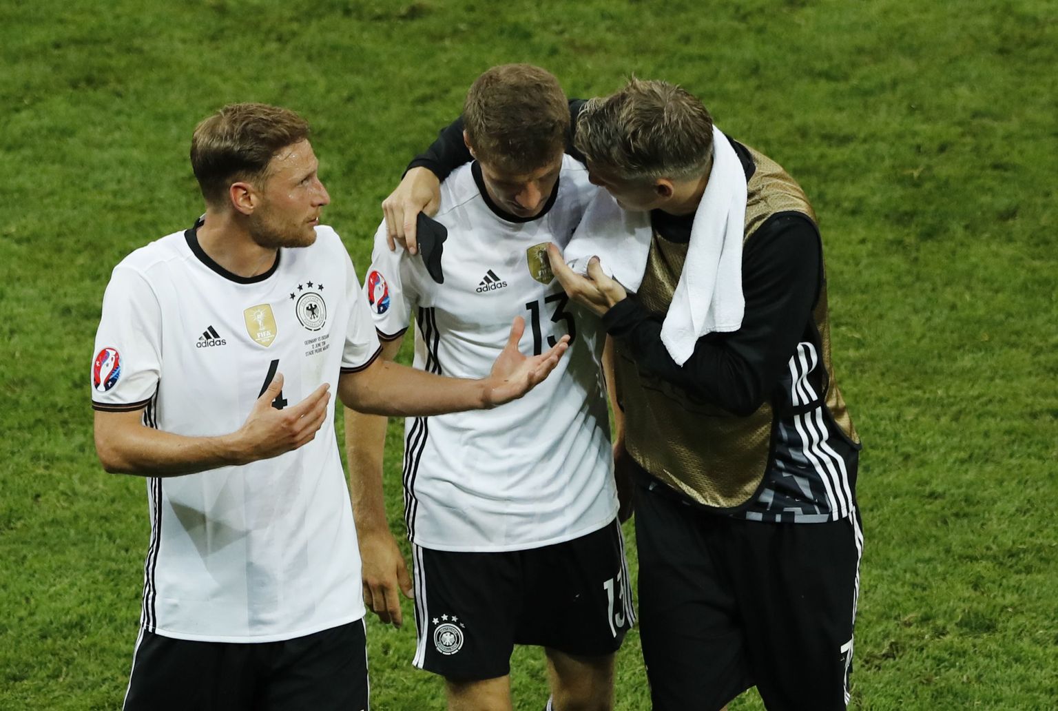 Thomas Müller (keskel) kuulamas koondise kapteni Bastian Schweinsteigeri (paremal) õpetussõnu.