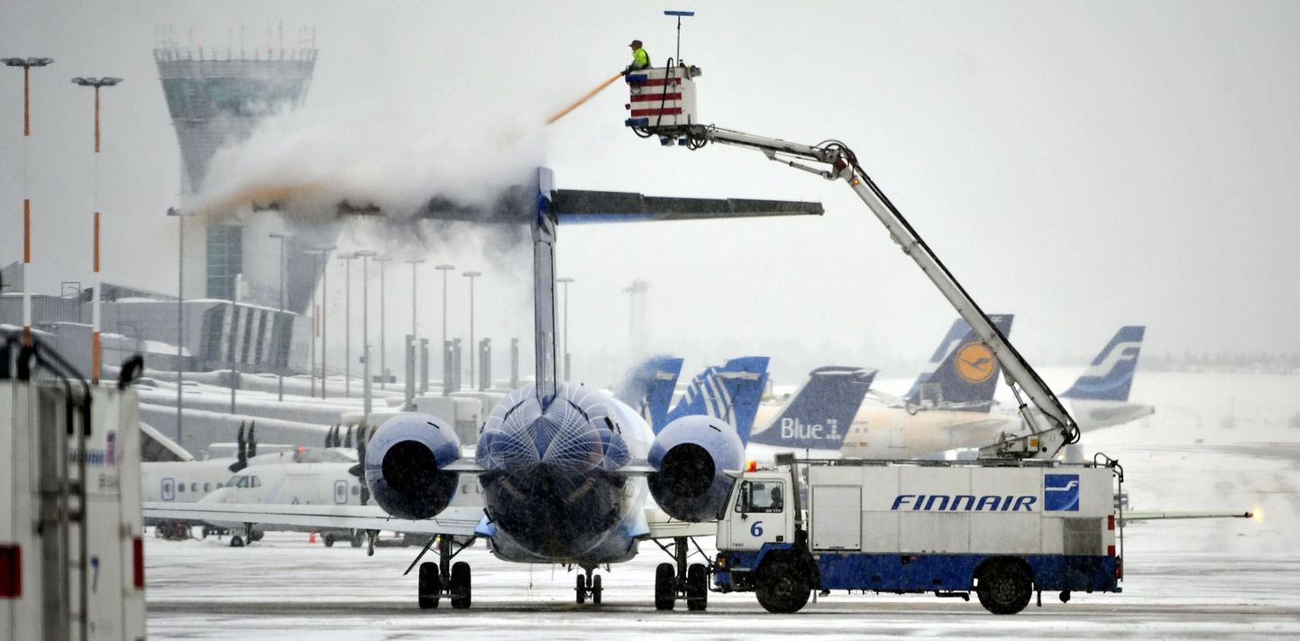 Finnairi töötaja pihustab Vantaa lennuväljal seisvale reisilennukile jäätumist takistavat ainet.