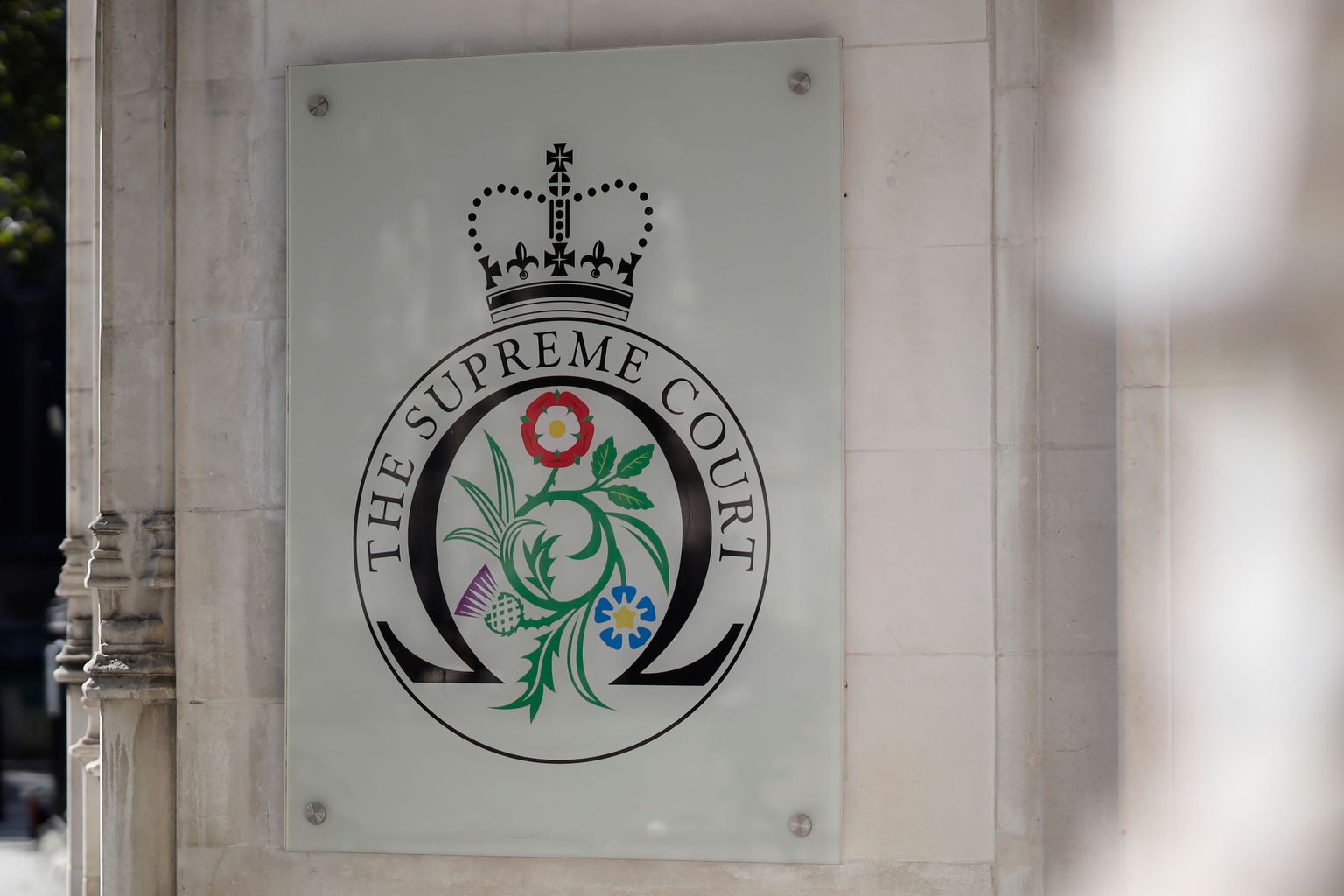 The logo for the Supreme court at the entrance to the court in central London on the third and final day of the hearing into the decision by the government to prorogue parliament on September 19, 2019. (Photo by Tolga Akmen / AFP)