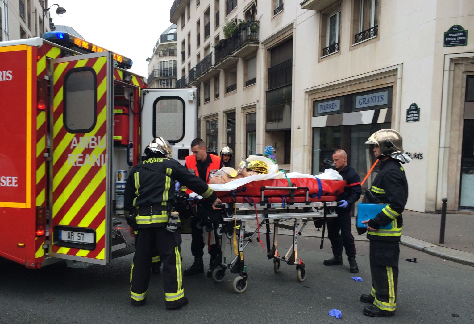 Из редакции газеты Charlie Hebdo в Париже выносят раненого.