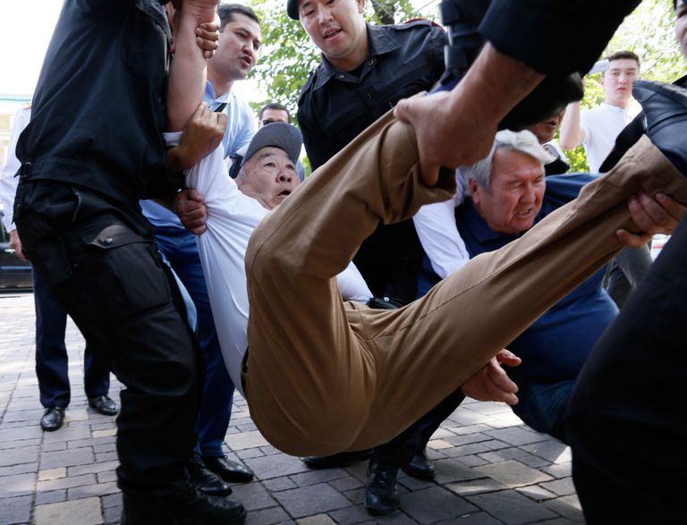 Korrakaitsjad Almatõs meeleavaldajat vahistamas.