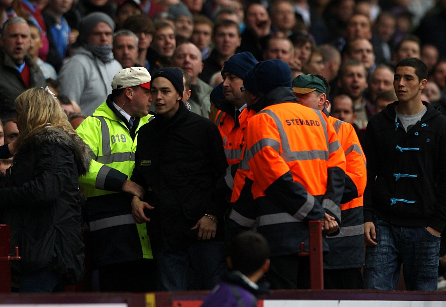 Turvamehed võtsid palli väljakule visanud noore Aston Villa poolehoidja Kieran Comerfordi (keskel mustas) kinni ja eemaldasid ta staadionilt.