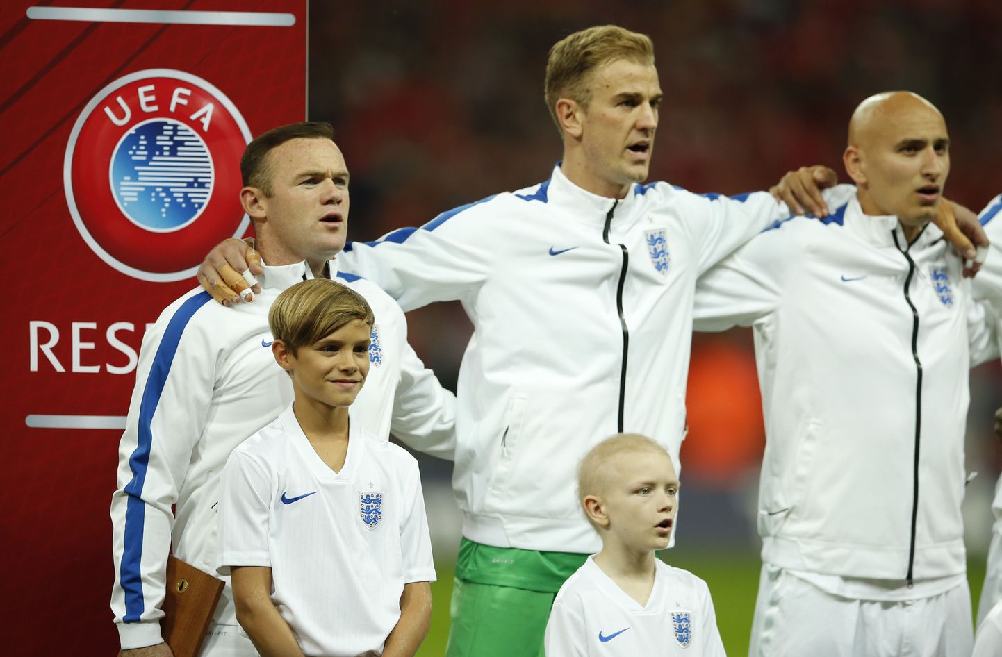 Уэйн Руни (слева) поет гимн Англии перед матчем со Швейцарией. Рядом с ним - сын Дэвида Бекхэма Ромео.