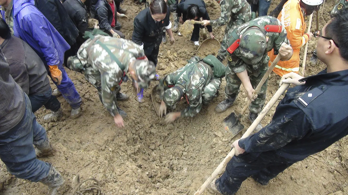 Poolmilitaarse politseiüksuse liikmed otsivad maalihke ohvreid Zhenhe külas (Yunnani provintsis), kus muda mattis enda alla algkooli.