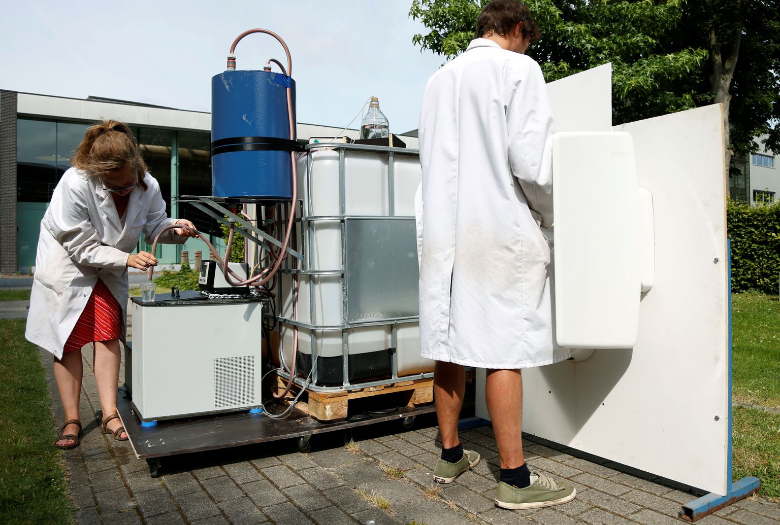 Belgian teadlased Marjolein Vanoppen and Sebastiaan Derese näitavad masinat, mis päikeseenergia toel pissi veeks muudab.