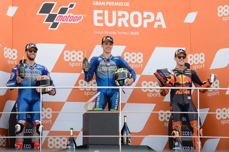 Race winner Suzuki Ecstar's Spanish rider Joan Mir (C) celebrates on the podium with Suzuki Ecstar's Spanish rider Alex Rins (L) and Red Bull KTM Factory Racing's Spanish rider Pol Espargaro after the MotoGP race of the European Grand Prix at the Ricardo Tormo circuit in Valencia on November 8, 2020. (Photo by JOSE JORDAN / AFP)