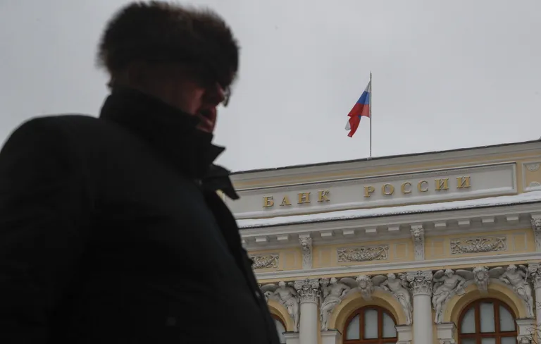Foto: A man in an ushanka hat passing the main building of the Russian central bank in Moscow on Dec. 15, 2023. Photo: MAXIM SHIPENKOV/EPA