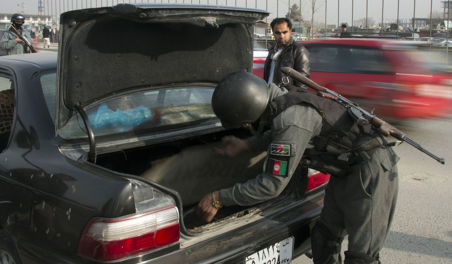 Afganistani politseinik kontrollib sõiduauto pakiruumi Kabulis.