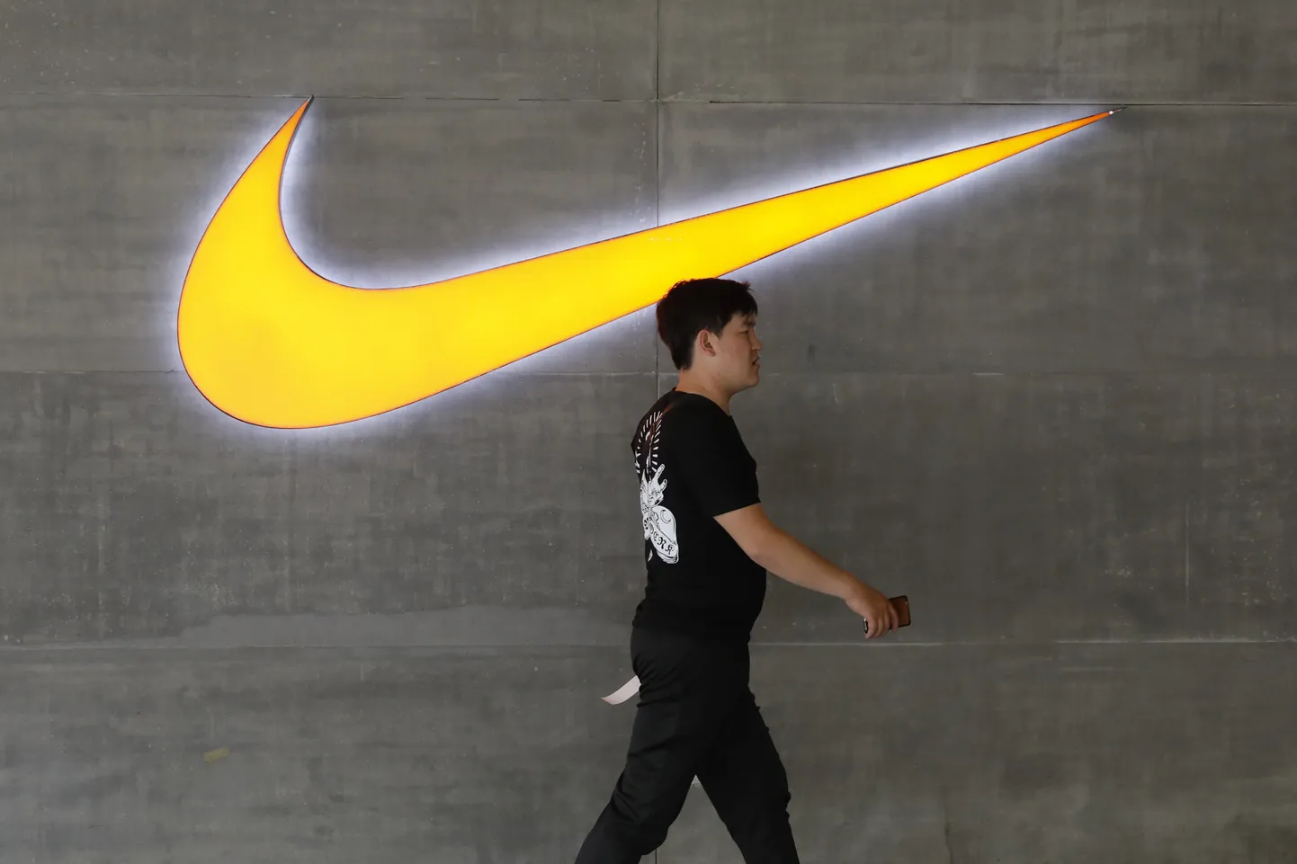 Hiina mees kõndimas mööda Nike poest Pekingis.