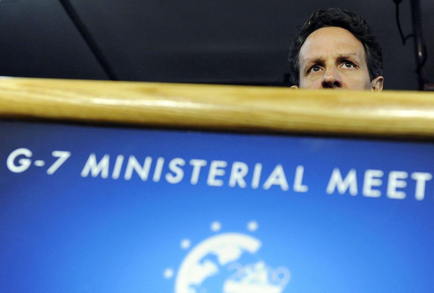 G7 riikide kohtumisest teavitava plakati tagant paistab USA rahandusminister Timothy Geithner.