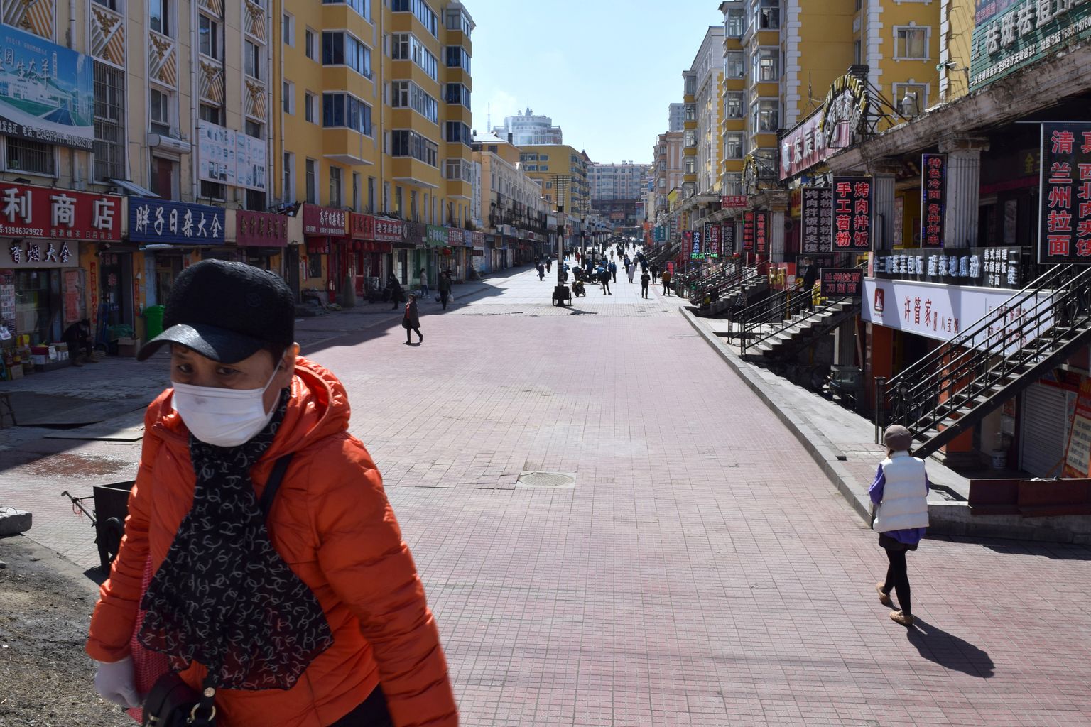 Maskis inimene liikumas Hiinas Heilongjiangi provintsis Suifenhes ostutänaval, kus on vähe inimesi