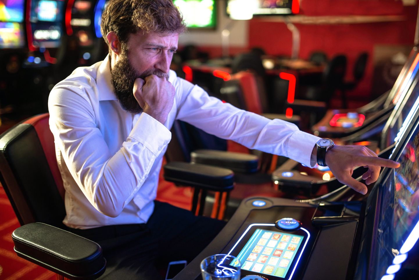 Mees kasiinos mänguautomaadiga mängimas. Pilt on illustreeriv