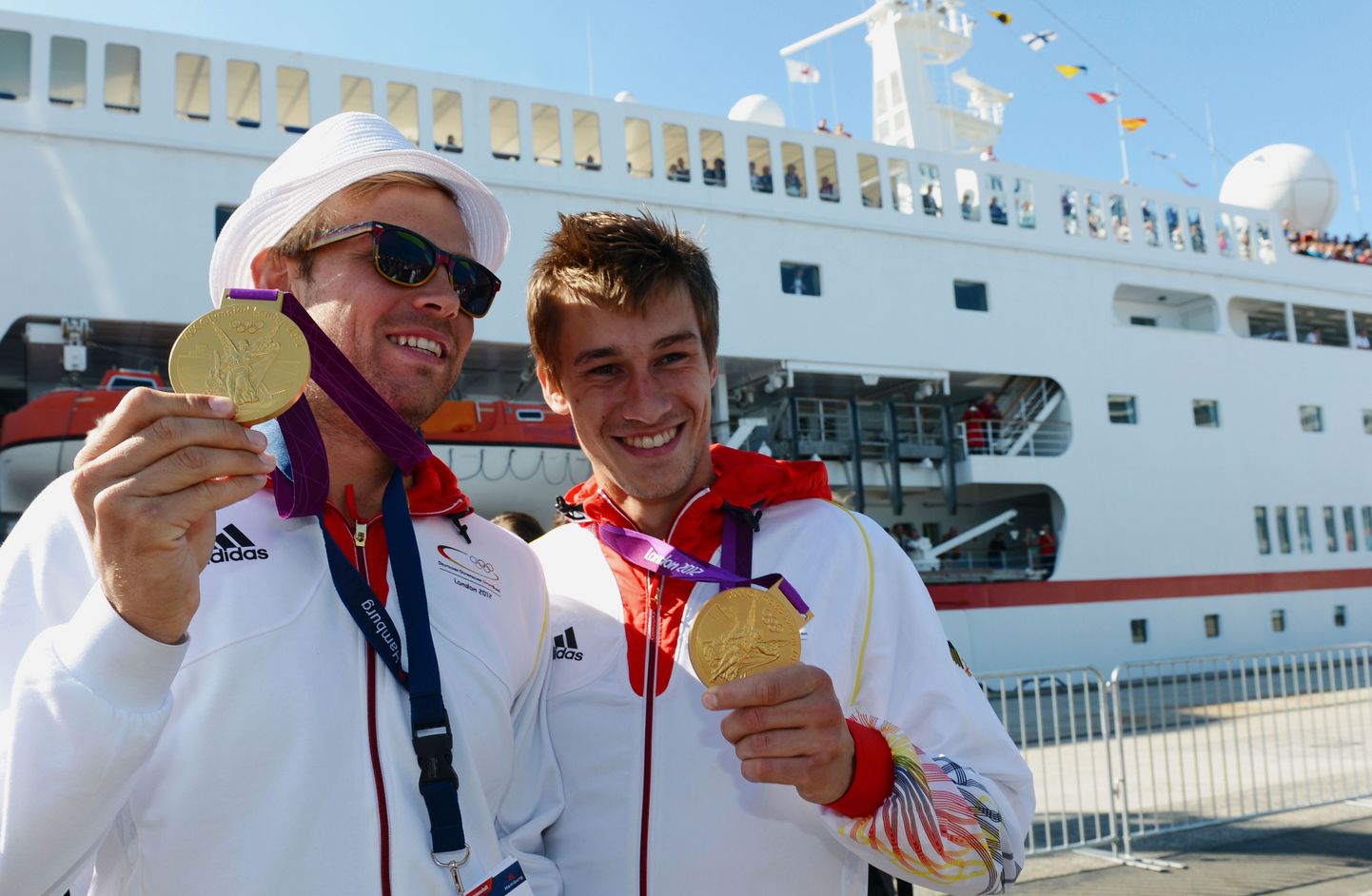 Moritz Fürste (vasakul) ja Florian Fuchs poseerivad kuldmedalitega MS Deutschlandi ees. Sama luksuslaevaga sõitsid kõik Saksamaa olümpialased Londonist kodumaale.