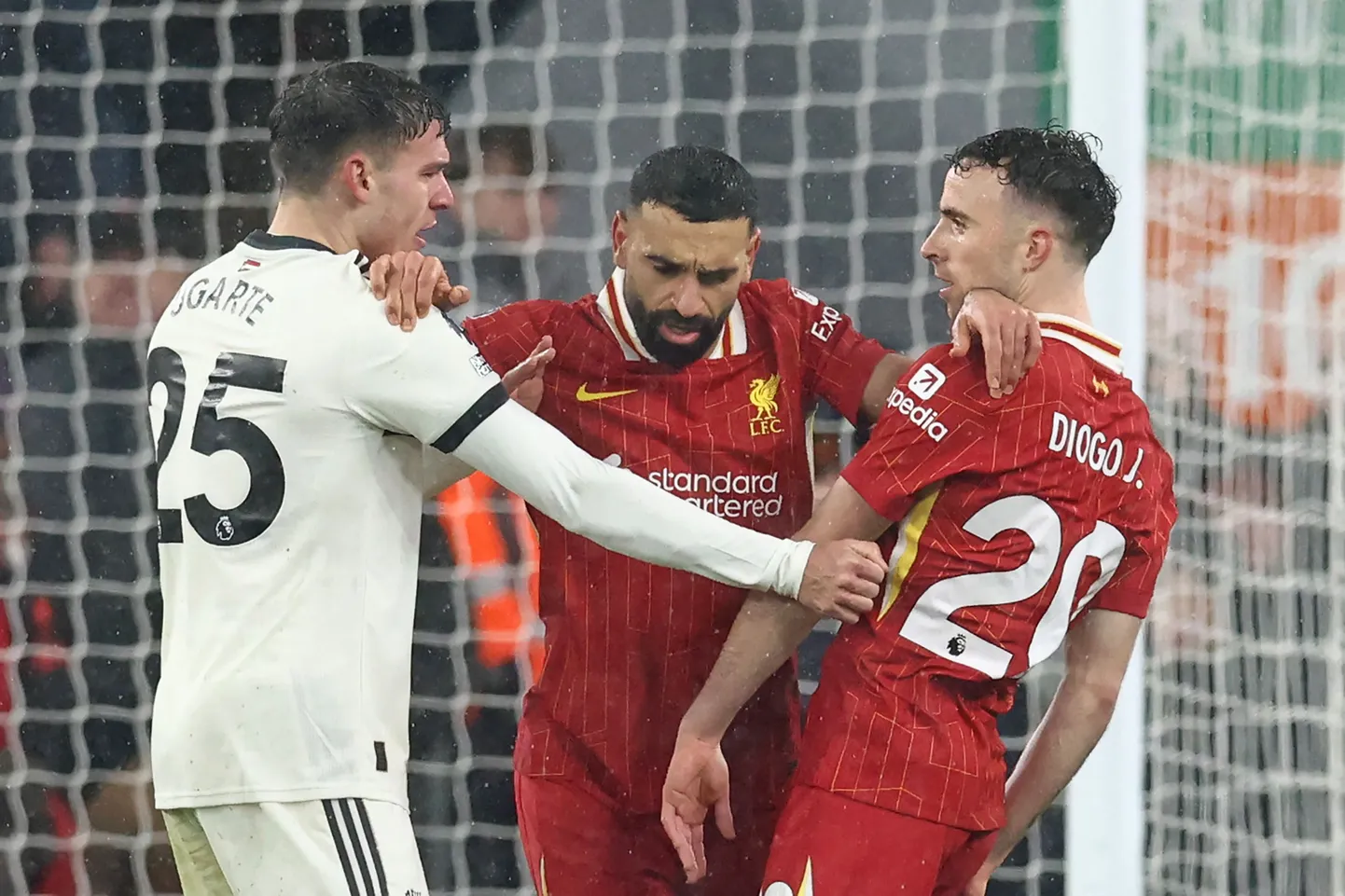 Manchester Unitedi poolkaitsja Manuel Ugarte (vasakul) ja Liverpooli ründaja Diogo Jota (vasakul) lahendavad erimeelsusi.  Olukorda tõttas klaarima Mohamed Salah (keskel).