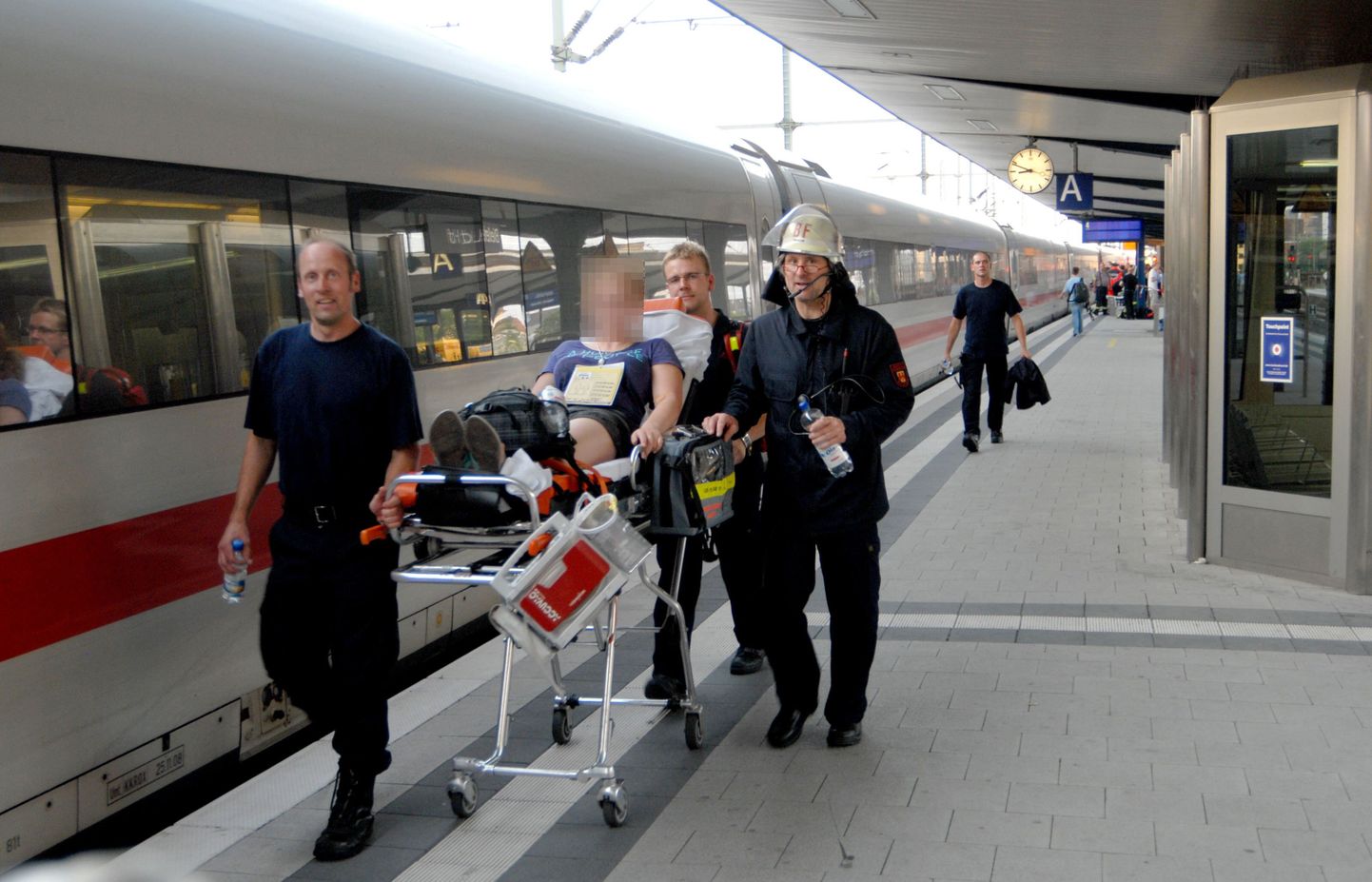 Работники спасательной службы увозят студента, которому стало плохо из-за жары в поезде. 11 июля, Билефельд, Германия.