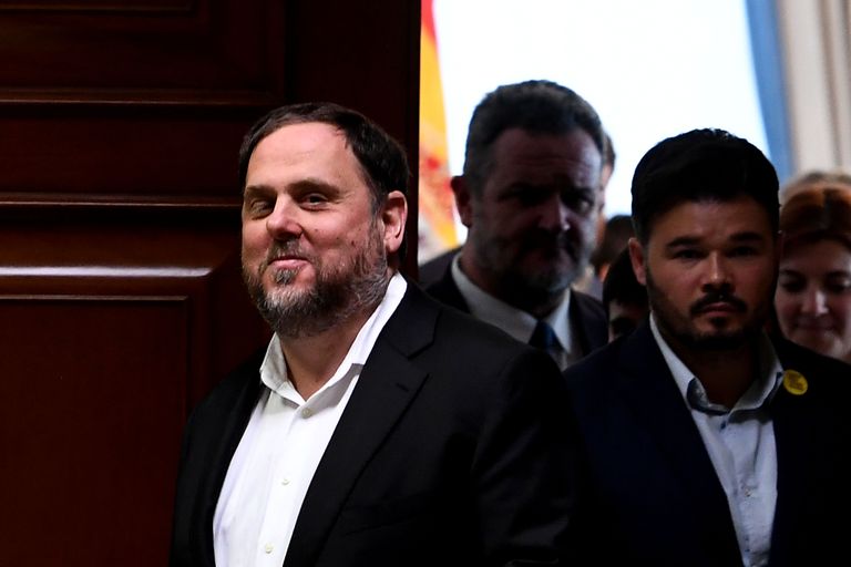 Catalonia's former vice-president and elected member of parliament Oriol Junqueras (L) smiles inside the Parliament building in Madrid on May 20, 2019, after being temporarily released to register as MP. - Five jailed Catalan separatists elected in polls last month will be allowed to attend the first day of Spain's national parliament on May 21, but the court also ruled against definitively releasing them. All five have been in custody for more than a year over their role in Catalonia's secession attempt in October 2017 and are currently on trial in Madrid, charged with rebellion. (Photo by PIERRE-PHILIPPE MARCOU / AFP)