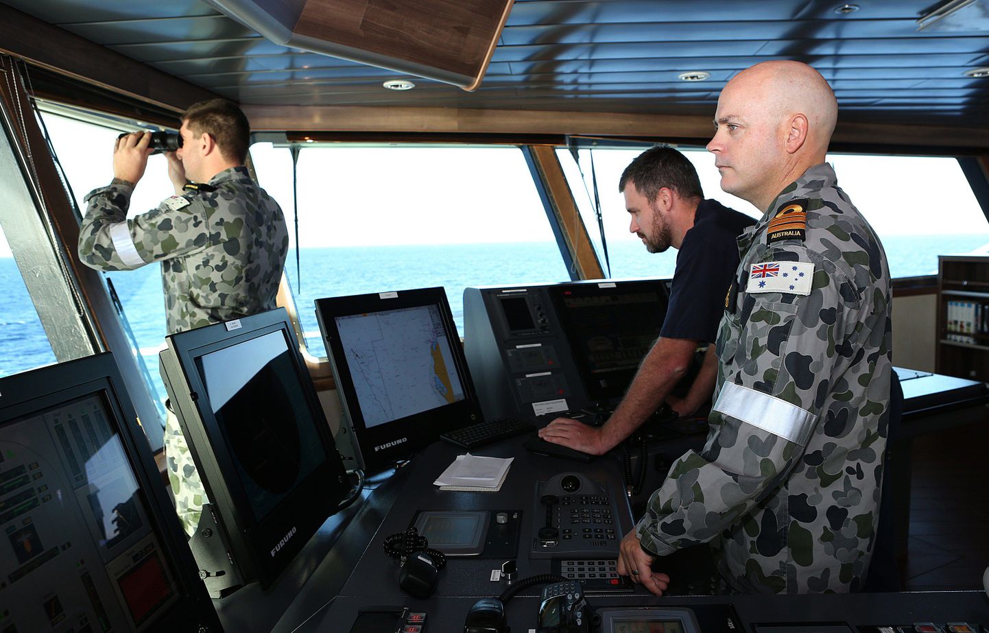 Austraalia mereväele kuuluva Ocean Shieldi juhid eesotsas kaptenleitnant  James Lybrandi (paremal) ja kapten Nick Woodsiga (keskel) otsivad Malaisia lennukit India ookeani lõunaosast.