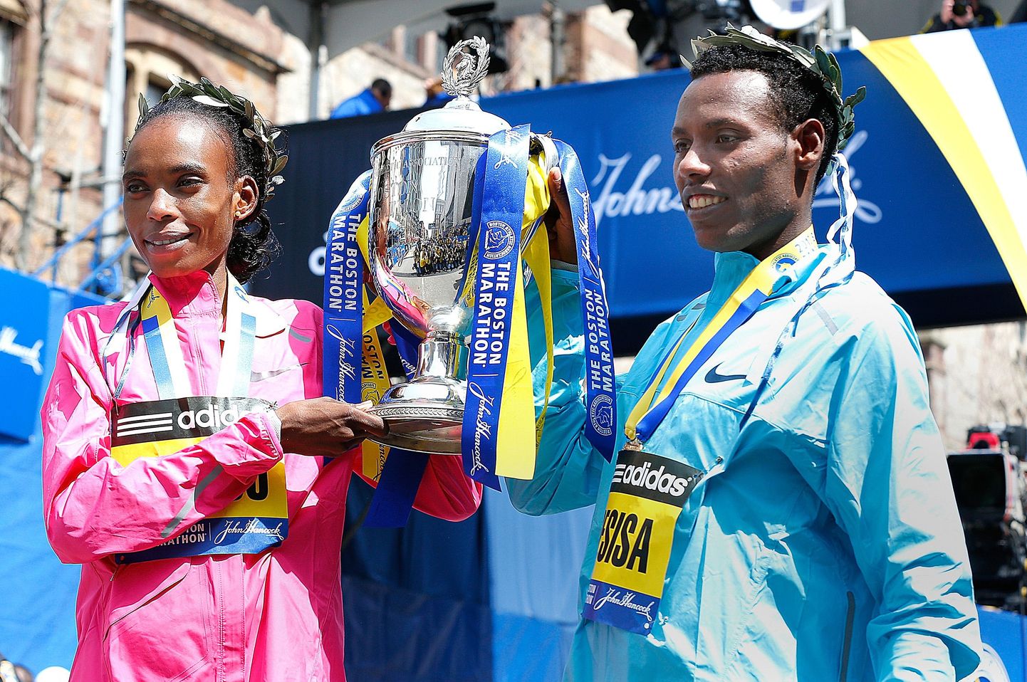 Rita Jeptoo (vasakul) ja Lelisa Desisa 2013. aasta Bostoni maratoni võidutrofeega.