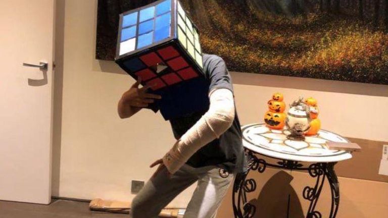 Молодой человек с кубиком Рубика на голове.