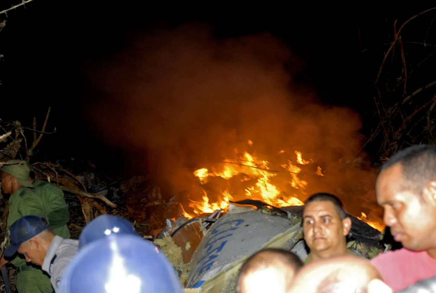 Firmale Aerocaribbean kuulunud lennuk kukkus alla Kuuba keskosas. Pildil on põlev vrakk, mille juures on politseinikud.