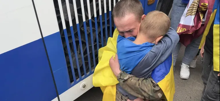 Украинский солдат Дмытро Гавриленко, проведший 17 месяцев в российском плену, обнимает своего маленького сына Тимура.